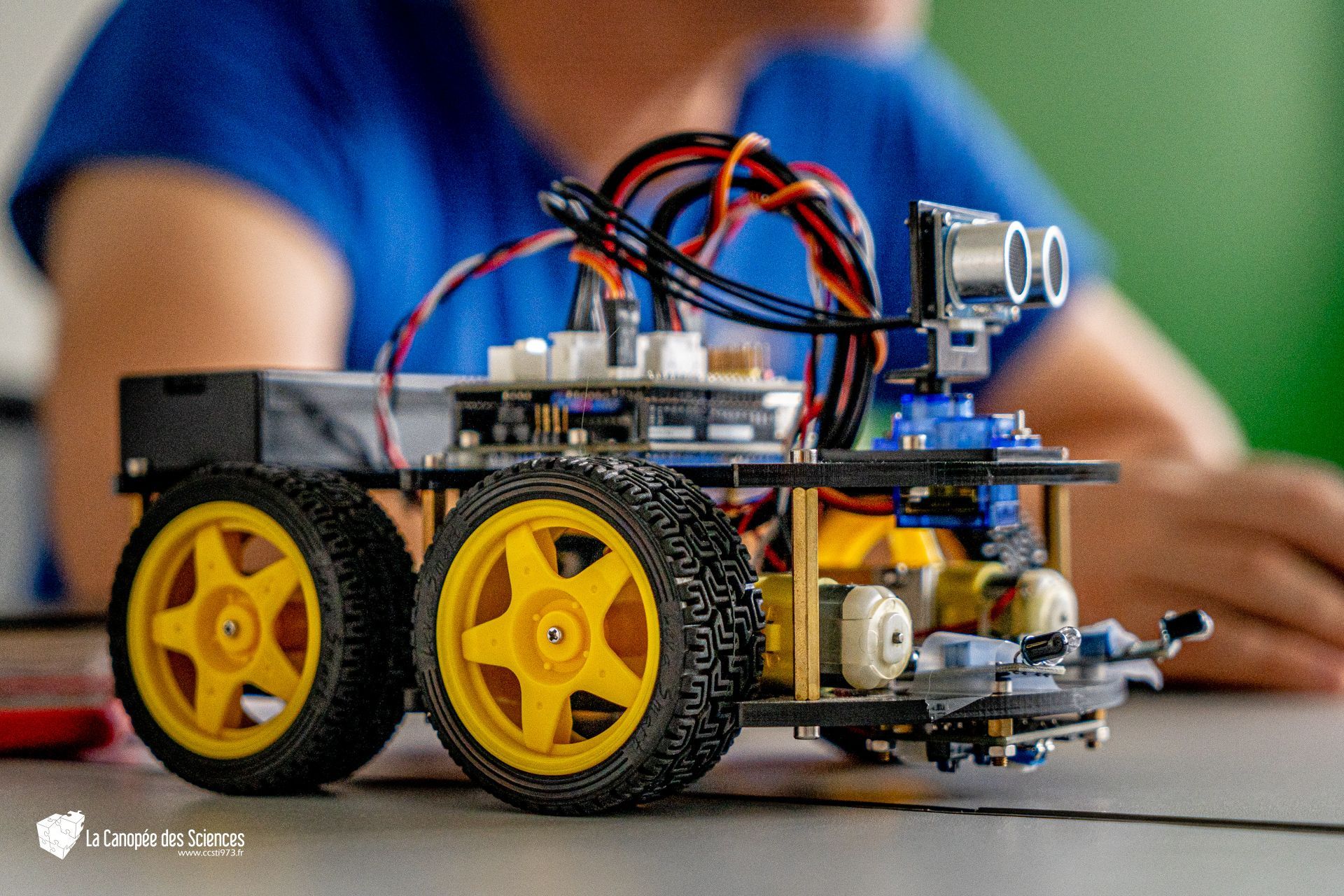 Un enfant joue avec un robot sur une table.