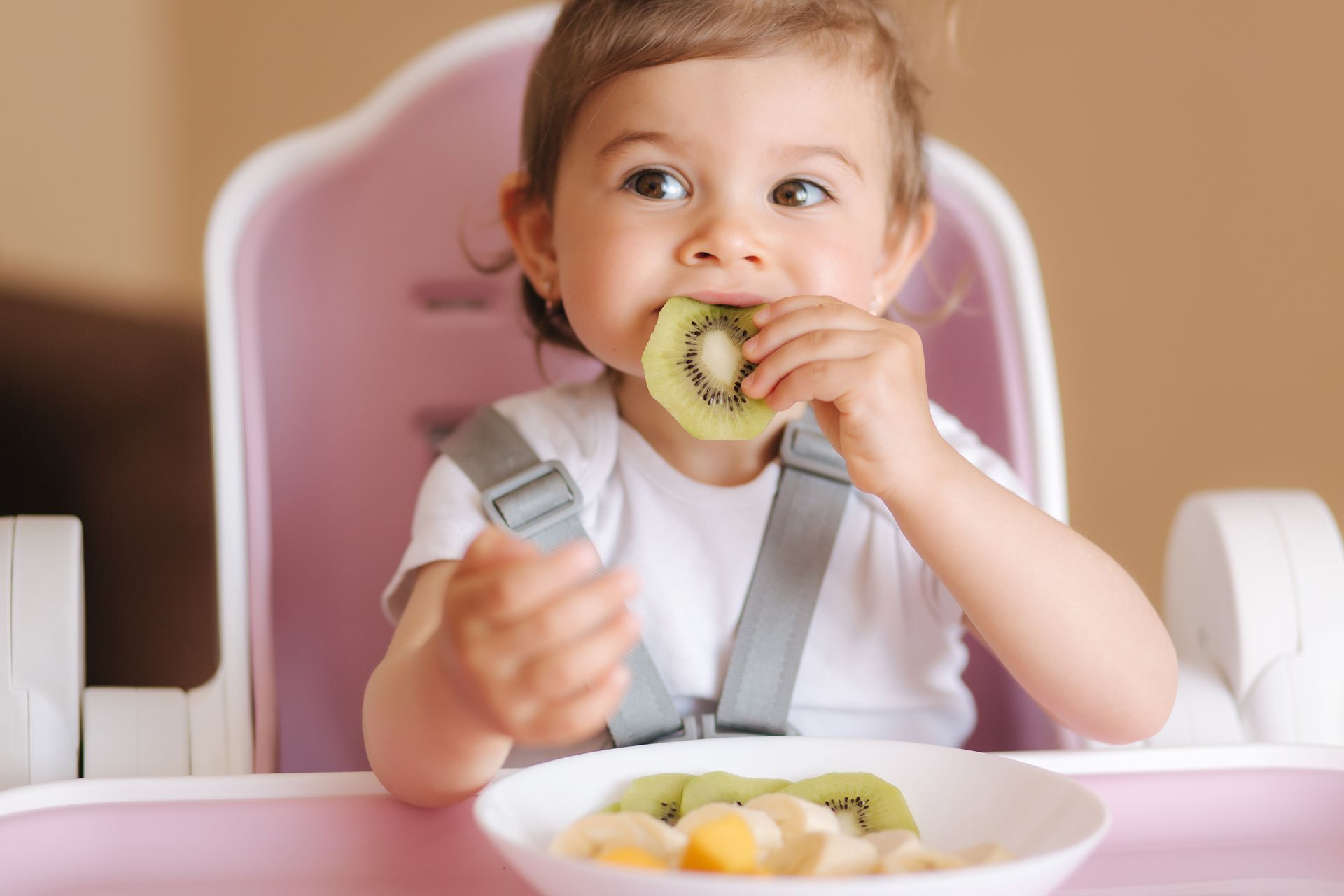 Baby in highchair exploring new foods — the Picky Eater Parenting course gives parents tools to support food discovery