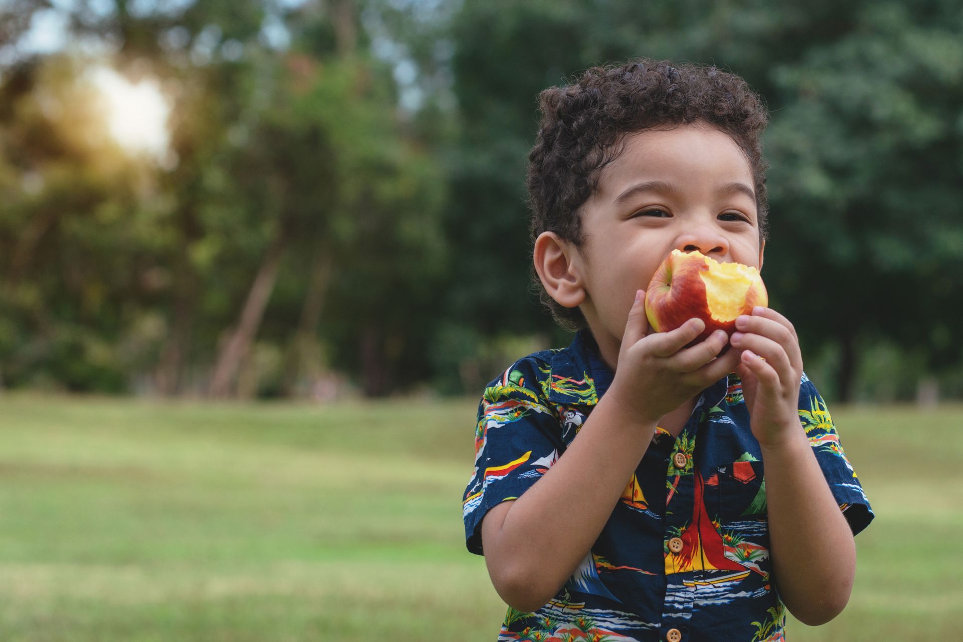 Happy child enjoying food outdoors — the goal of Picky Eater Parenting is confident, relaxed eating for your child