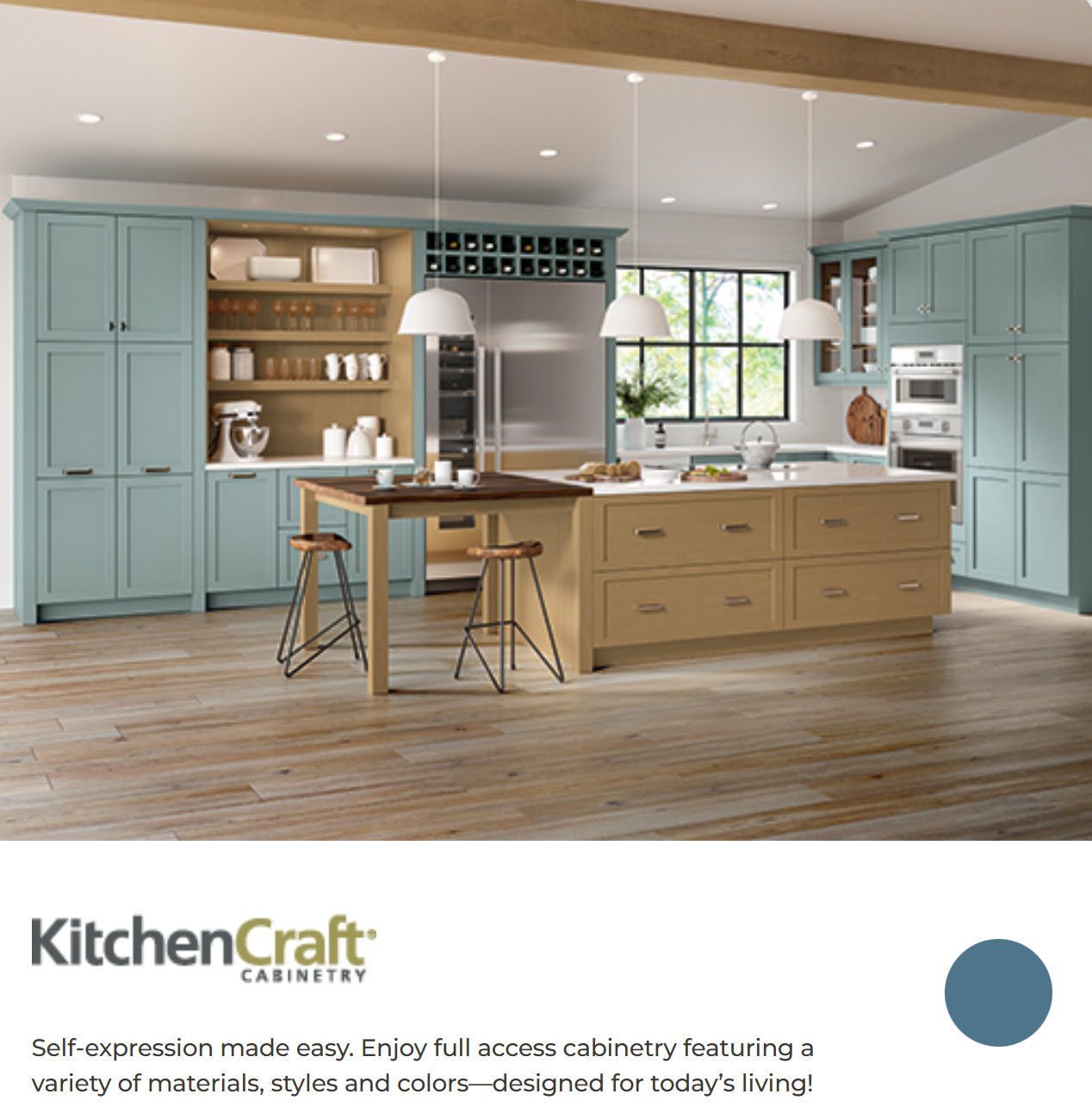 Modern kitchen with pale blue cabinets, wood island, pendant lights, and large window; KitchenCraft branding below