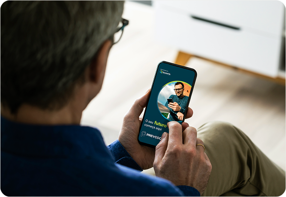 Homem olhando para smartphone, chamada de vídeo em andamento, rosto do homem na tela.