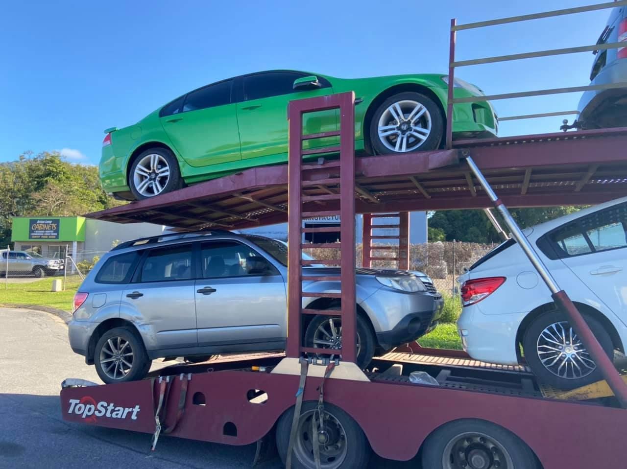 A Green Car Is Sitting On Top Of A Silver Car On A Trailer — Downsy's Cars In Bentley Park, QLD