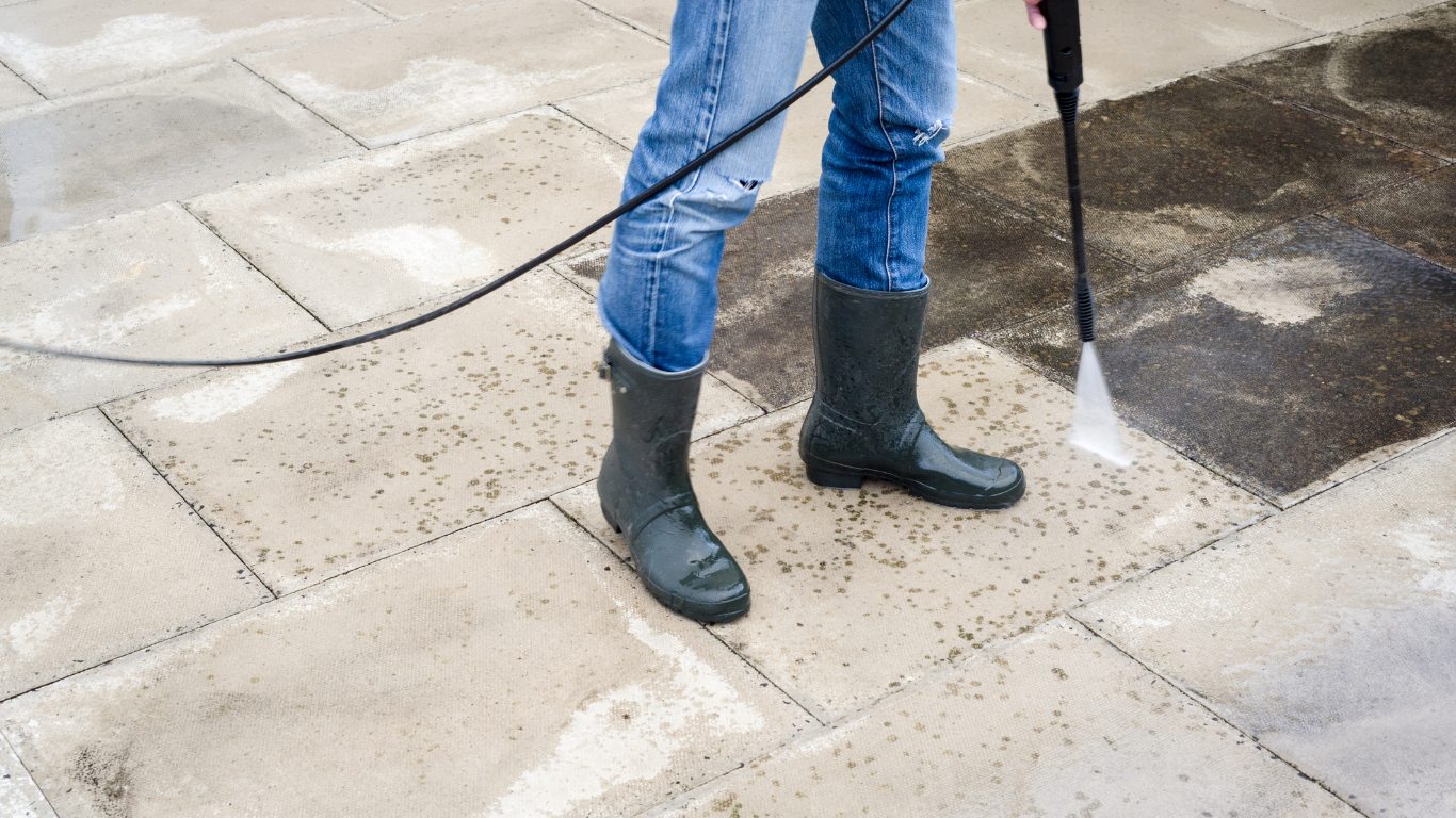 Power washing a backyard patio surface