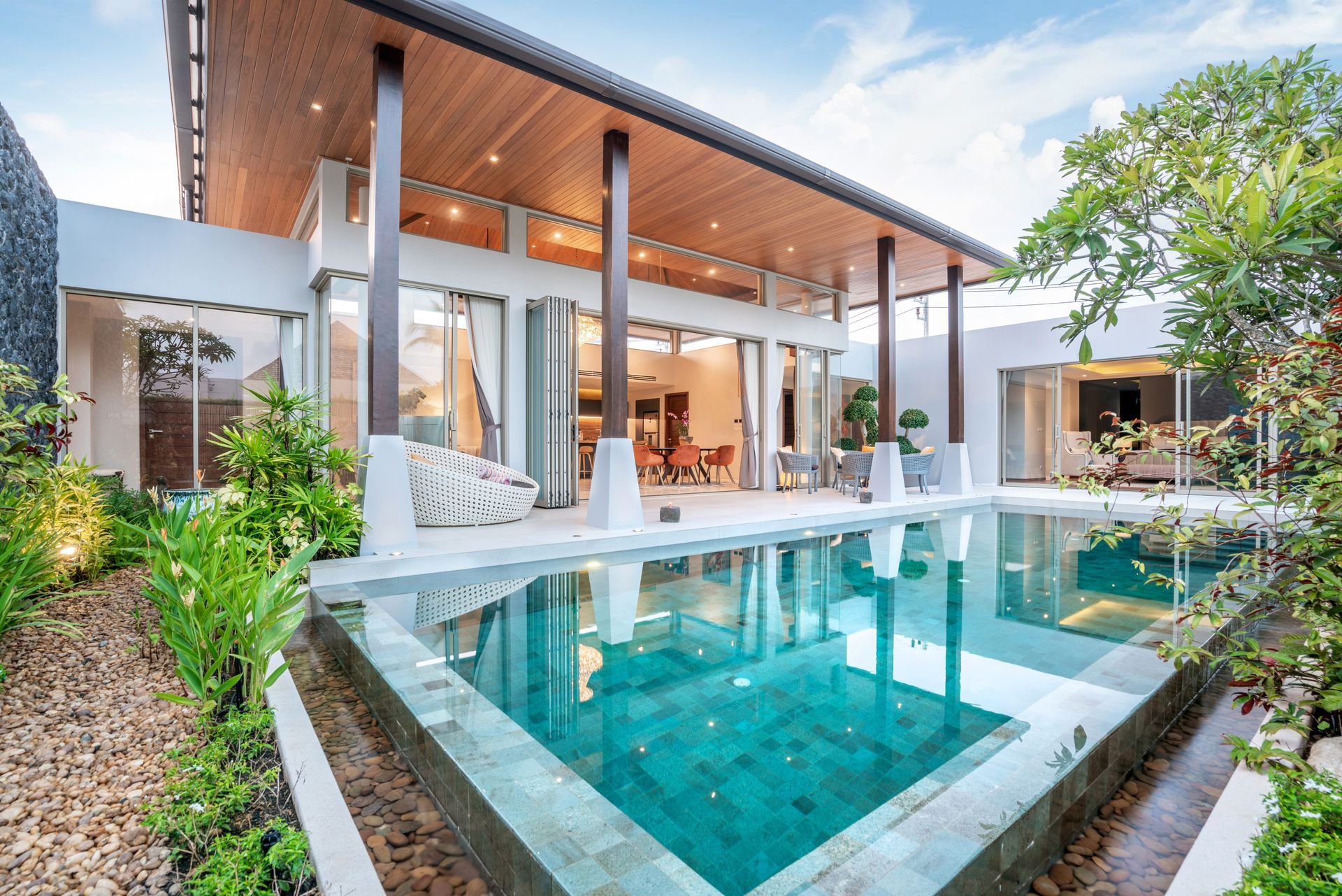 Modern villa with a turquoise pool and lush tropical landscaping