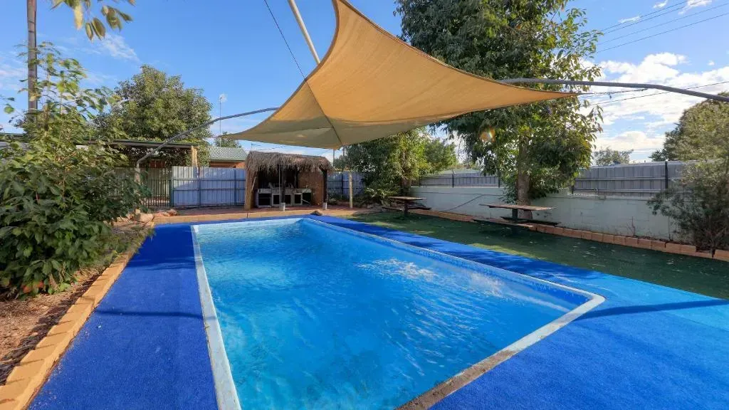 Pool with Blue Liner, Shaded by A Tan Sail — Townview Motel In Mount Isa, QLD