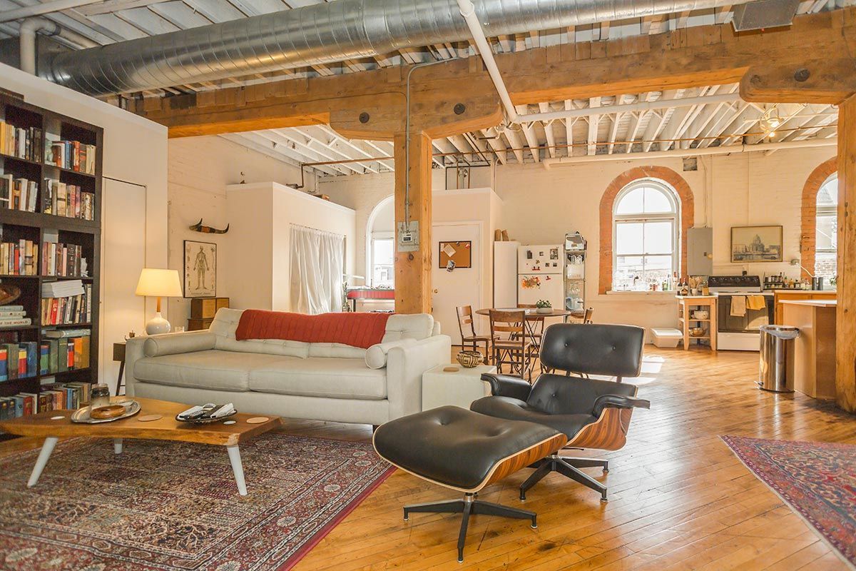 A living room with a couch , chair , coffee table and bookshelves.