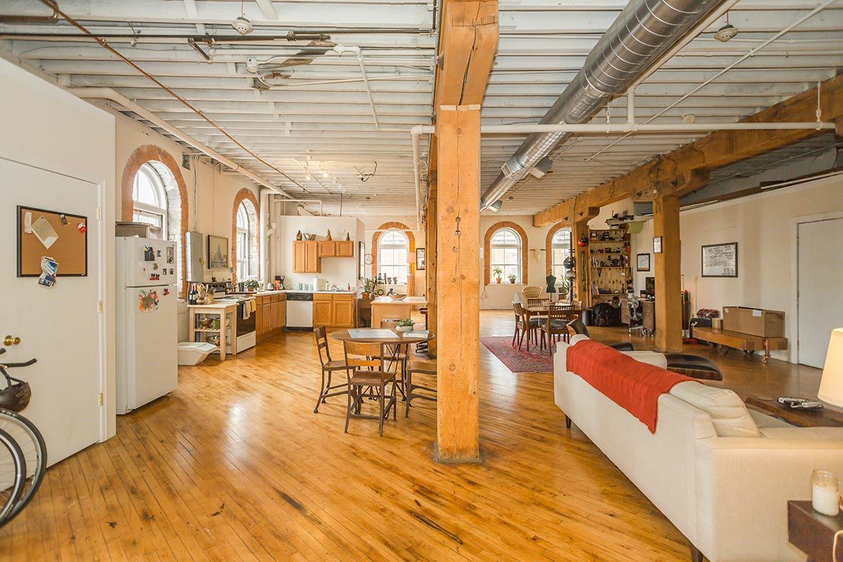 A living room with a couch , table , chairs and a bicycle.