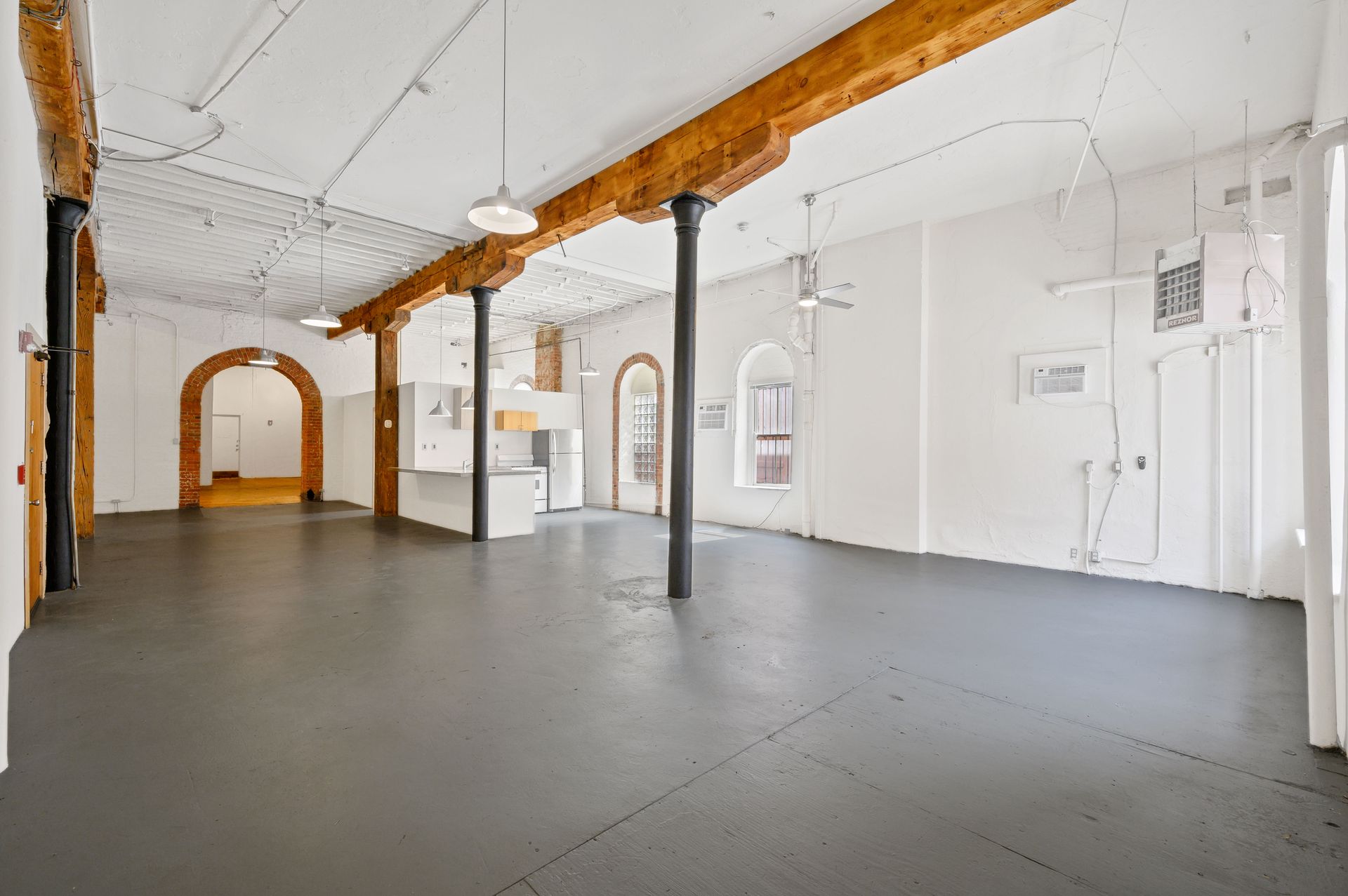 A large empty room with a gray floor and white walls.