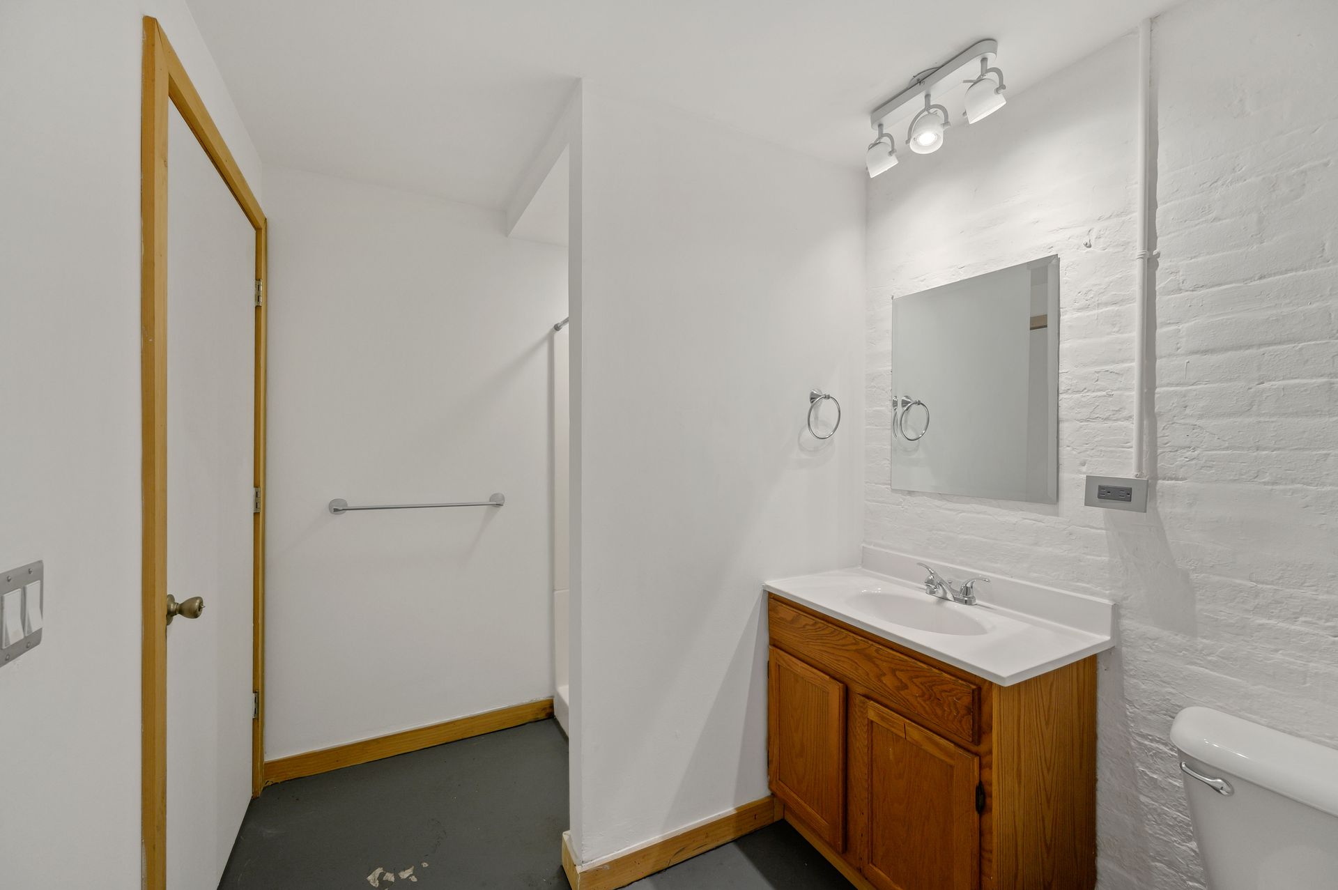 A bathroom with a sink , toilet and mirror.