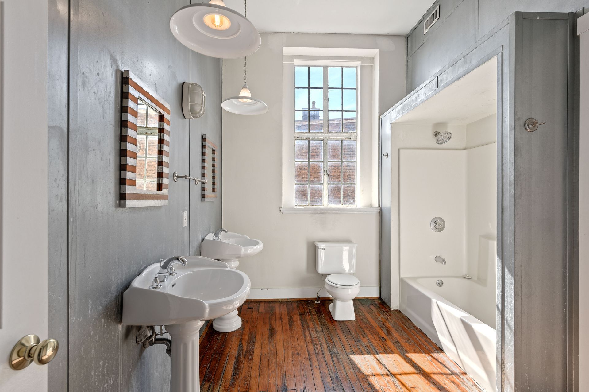 A bathroom with two sinks , a toilet , and a bathtub.