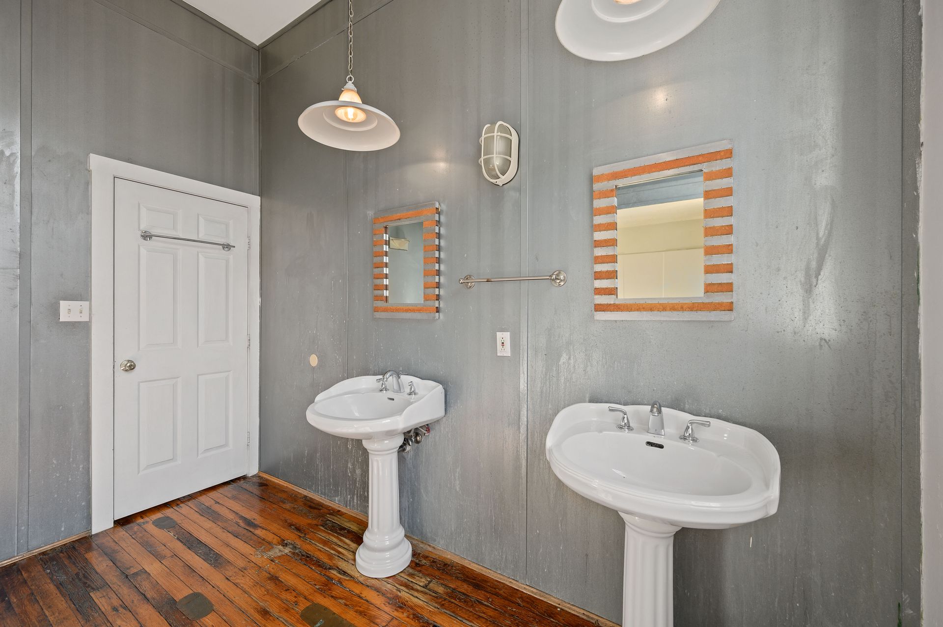 A bathroom with two sinks and two mirrors on the wall.