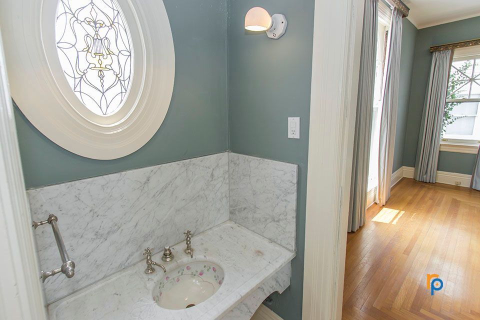 A bathroom with a sink and a stained glass window