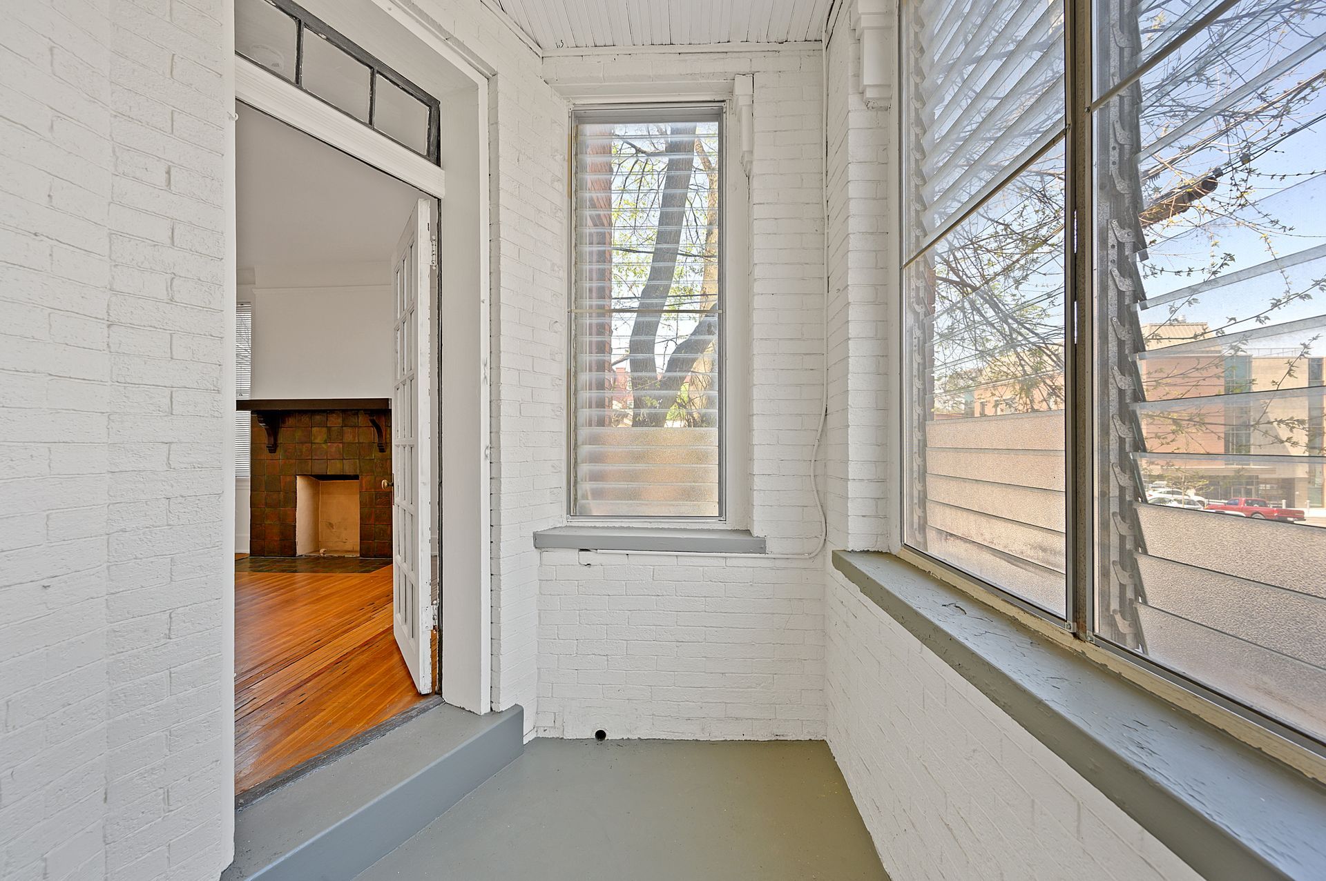 An empty room with a brick wall and a window