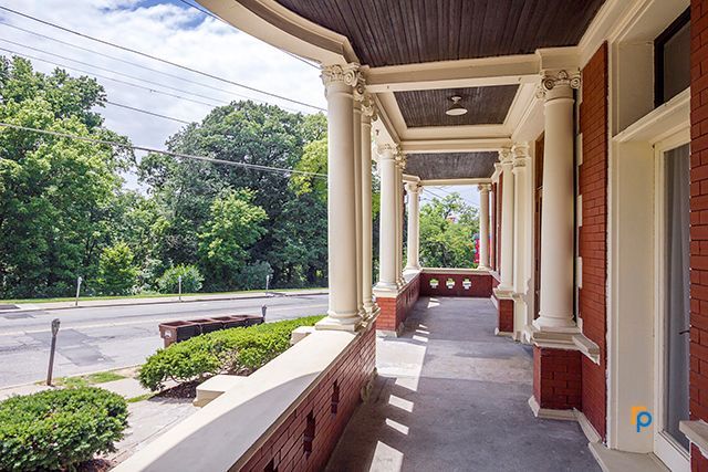 A brick building with a porch leading to the street.