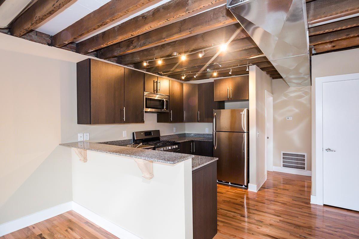 A kitchen with stainless steel appliances and wooden beams