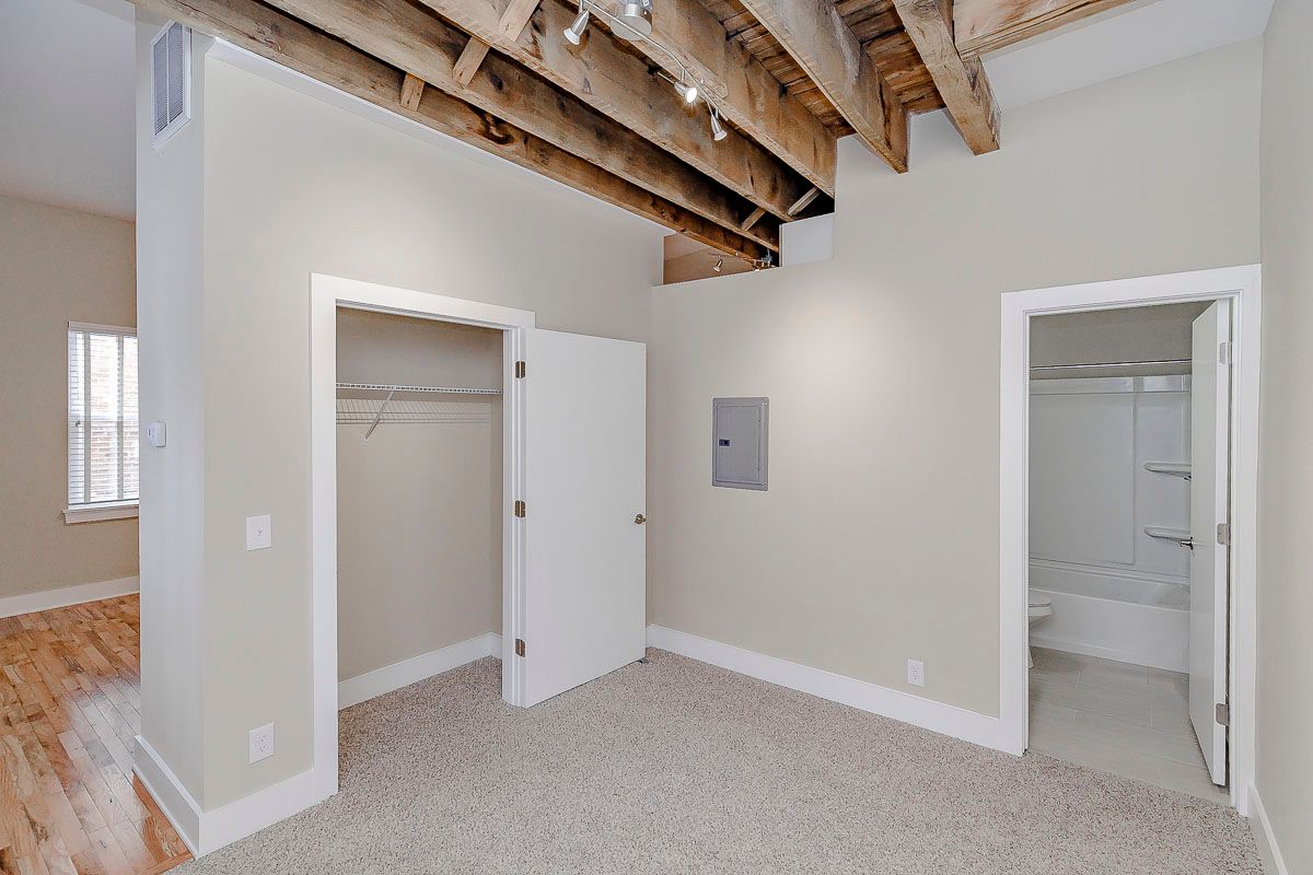 An empty bedroom with a closet and a bathroom.