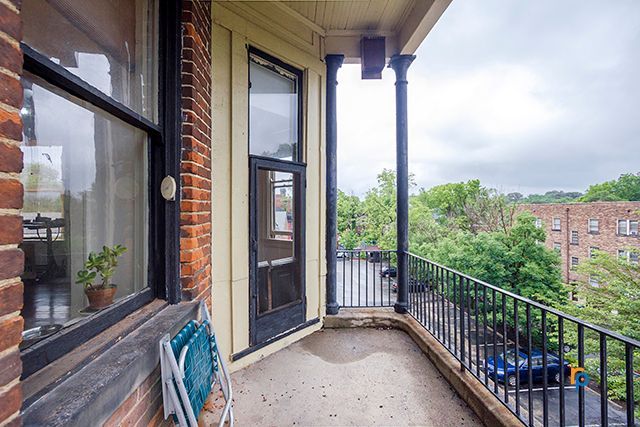 A balcony with a view of a city from a brick building.