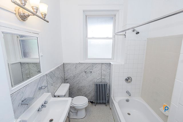 A bathroom with a toilet , sink , and bathtub.
