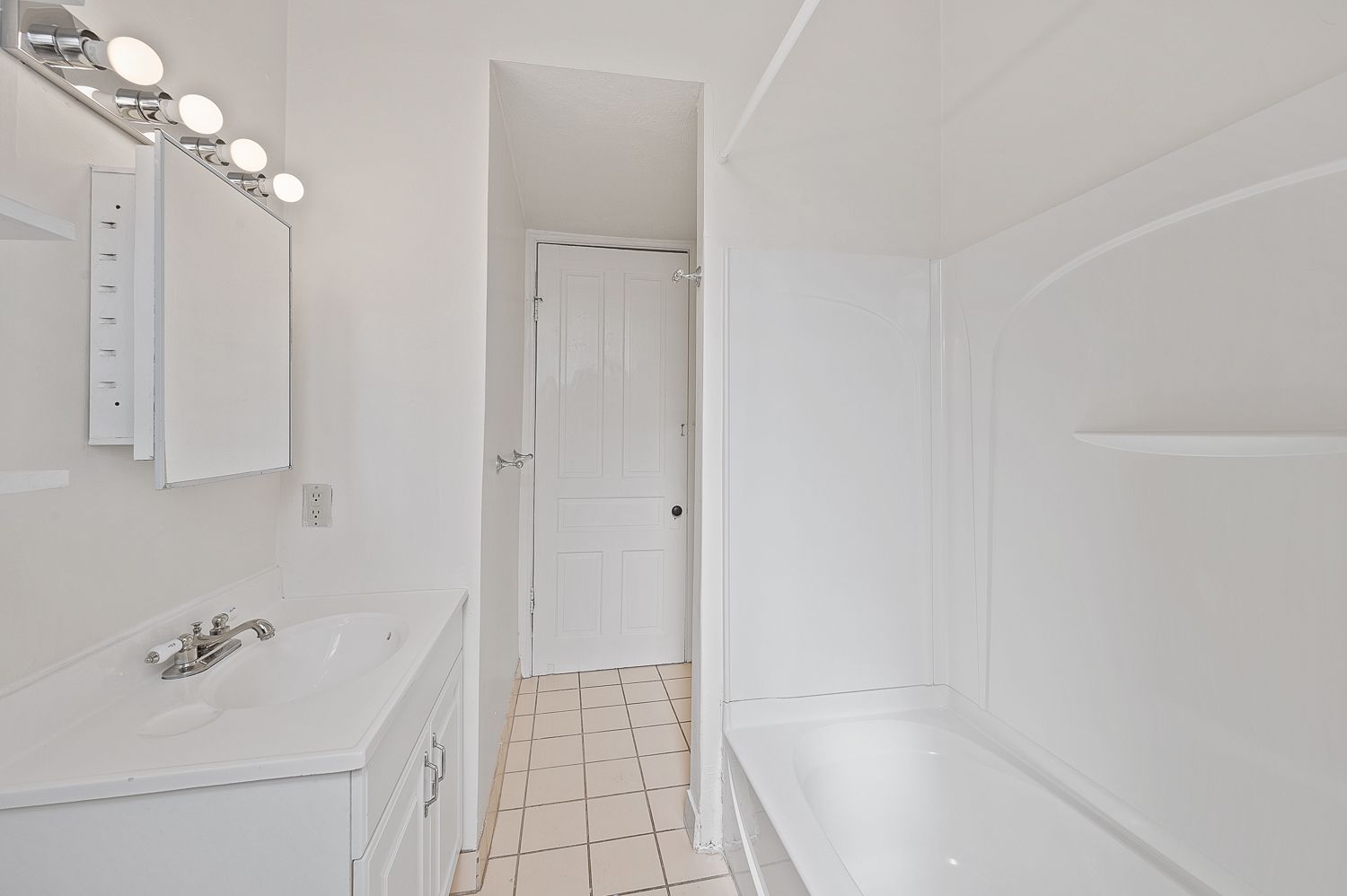 A bathroom with a sink , tub and mirror