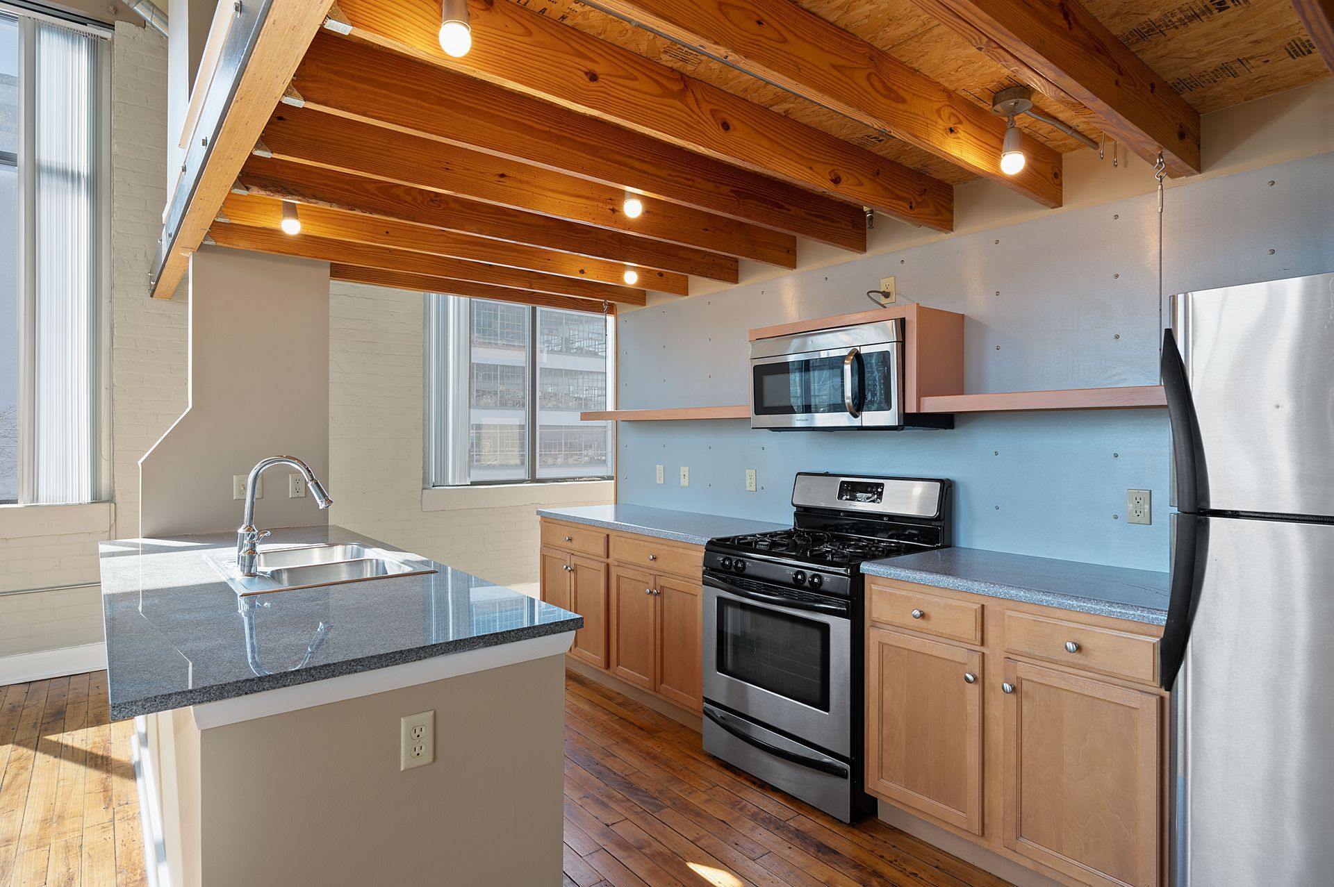 A kitchen with stainless steel appliances and wooden cabinets