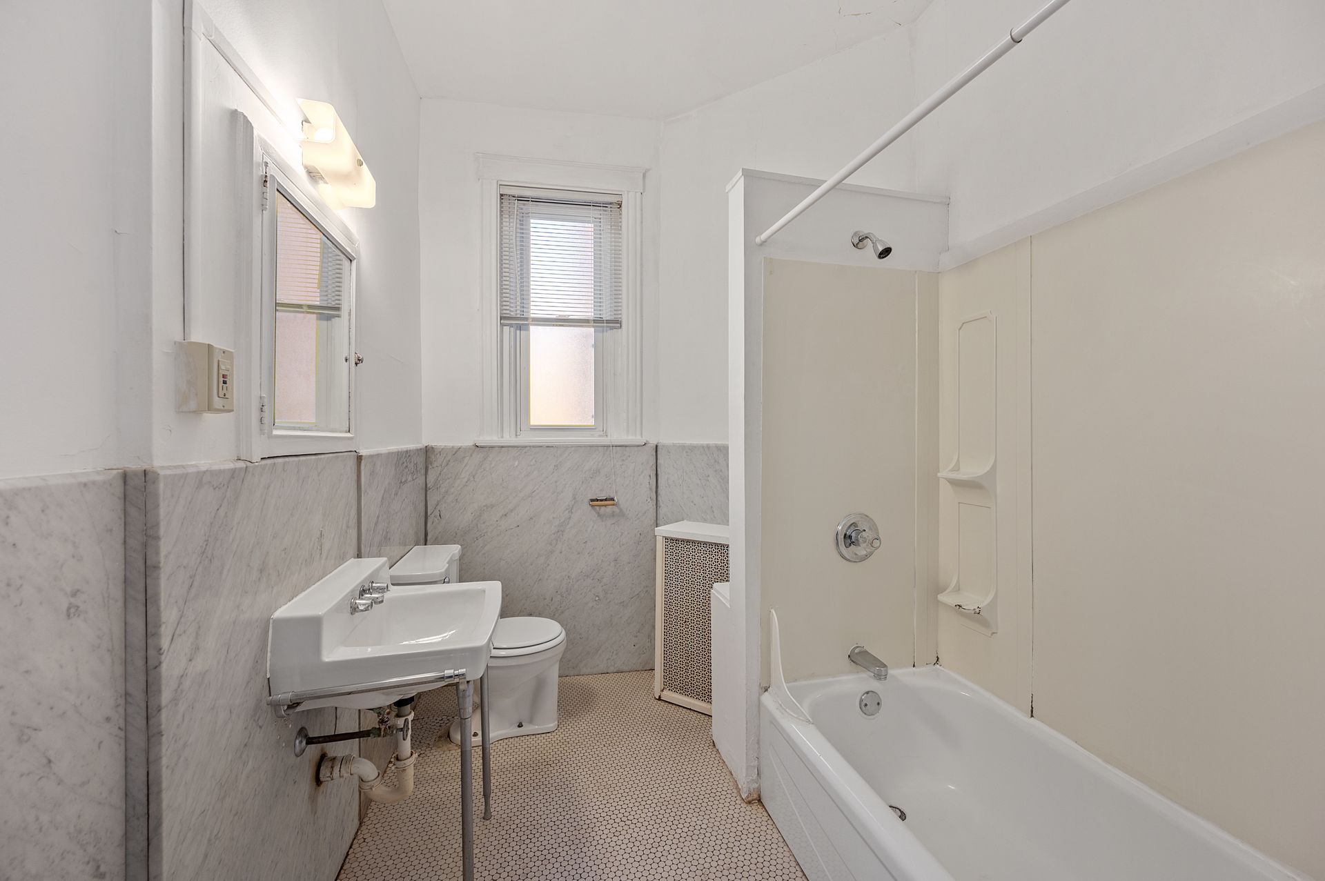 A bathroom with a sink , toilet , bathtub and window.