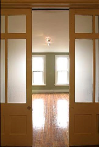 A sliding glass door opens to an empty room