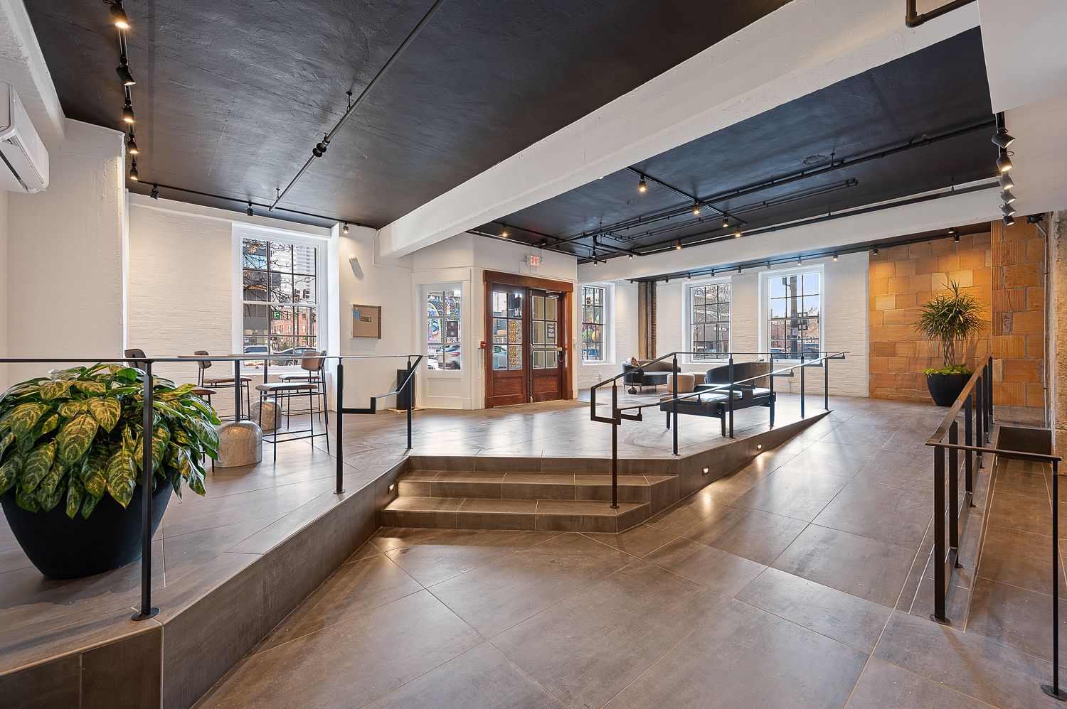 A large room with stairs leading up to a balcony.