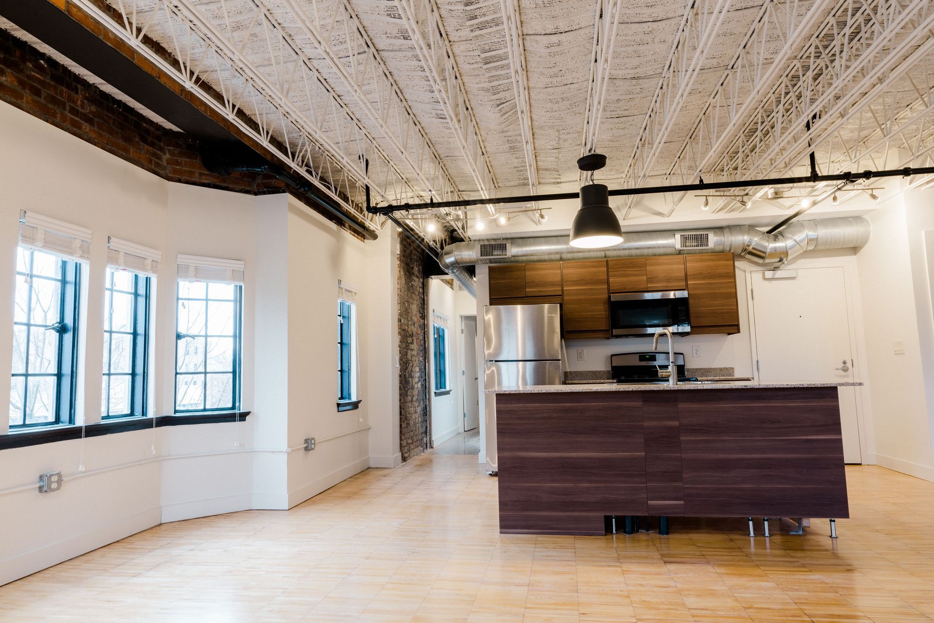 An empty kitchen with a large island in the middle of the room.