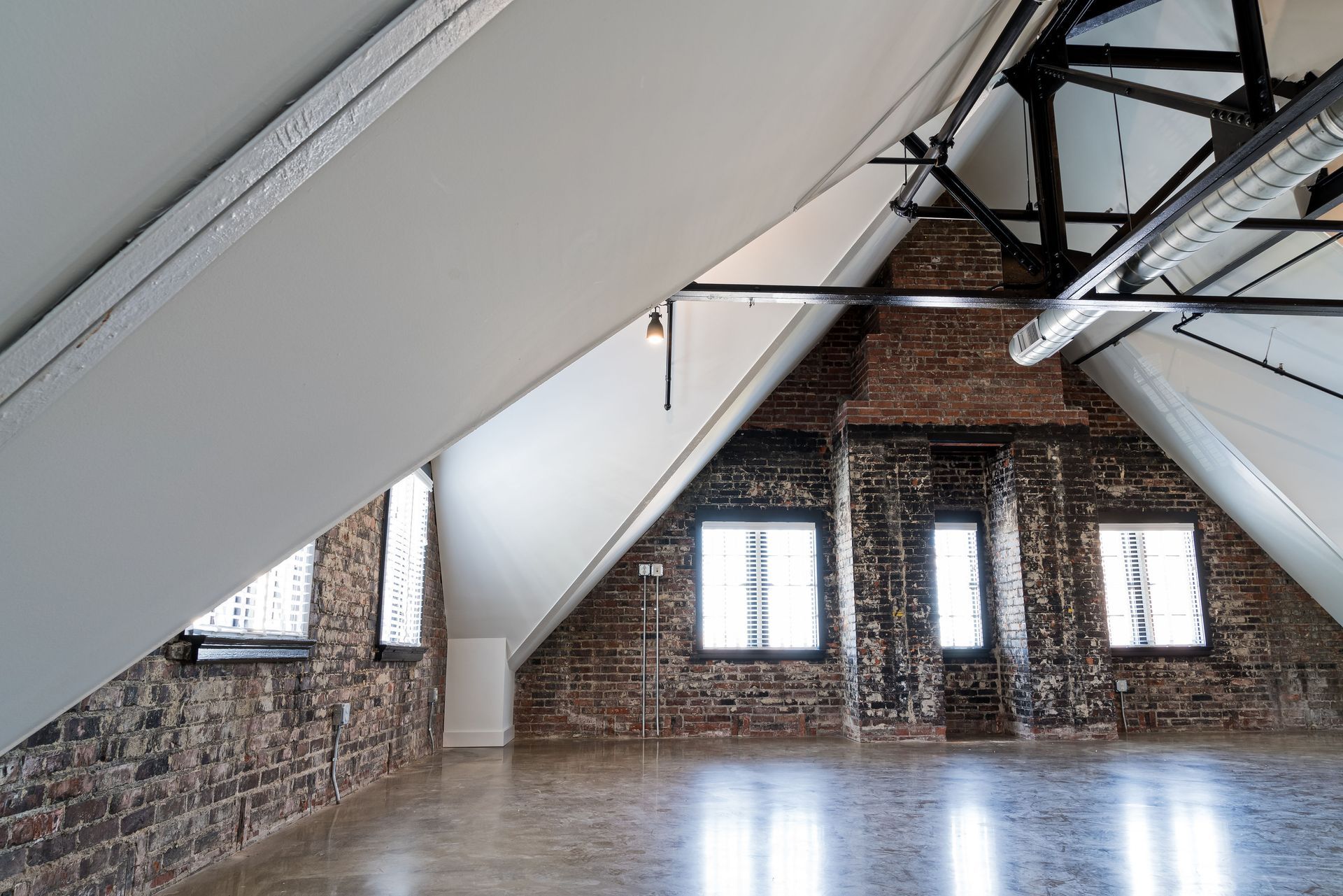 An empty room with brick walls and white ceilings