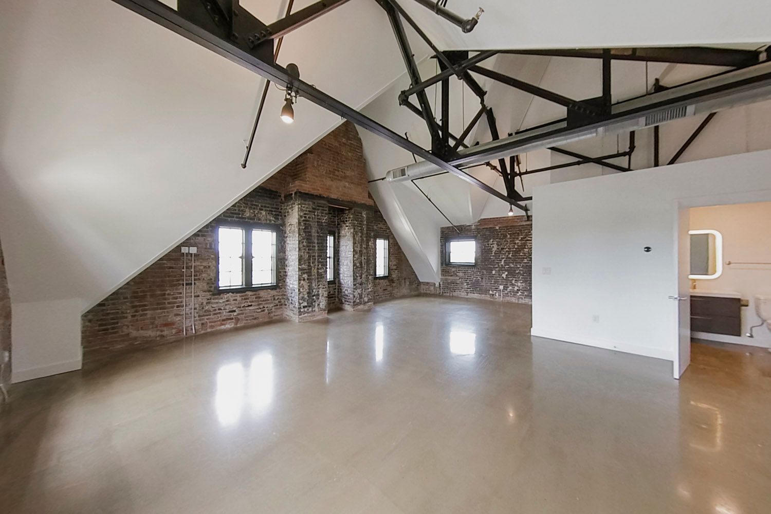 An empty room with a brick wall and a white ceiling