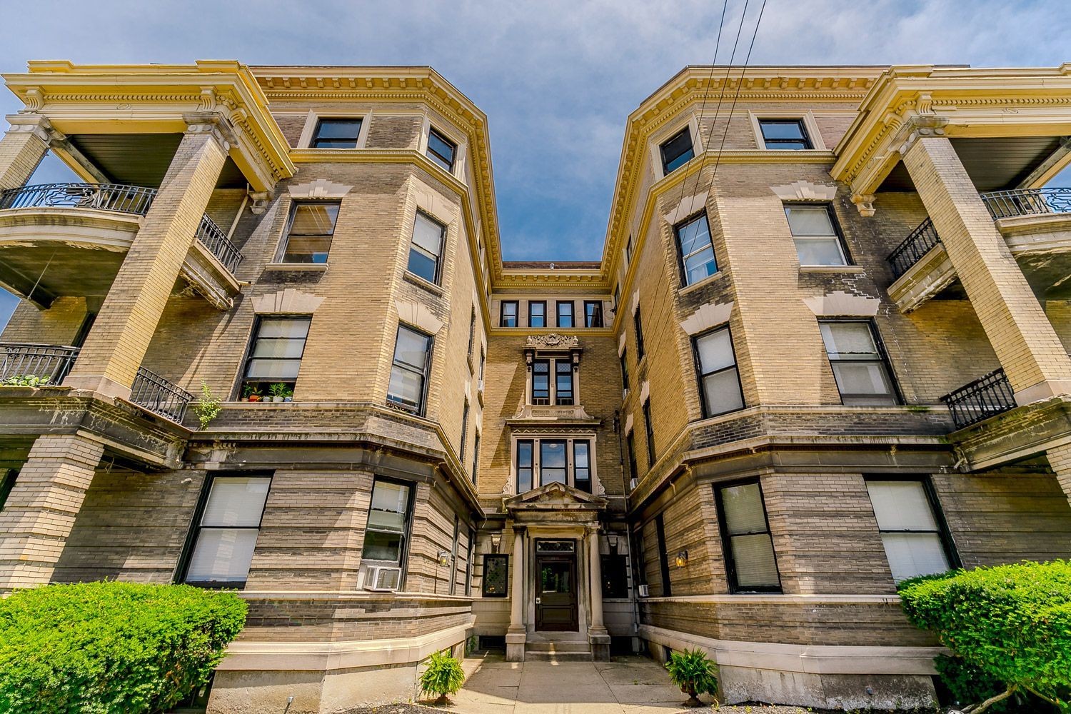 A large brick apartment building with a lot of windows and balconies.