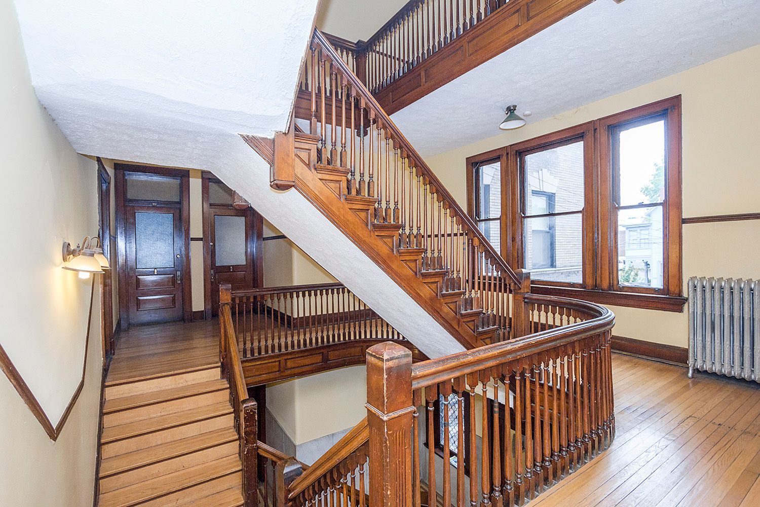 A large wooden staircase in a building with lots of windows