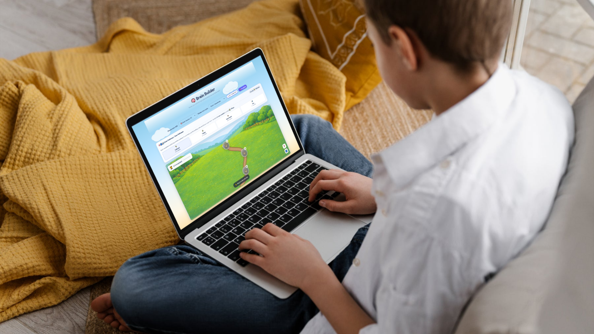 Person using a laptop on a couch, with a soccer game displayed on the screen.