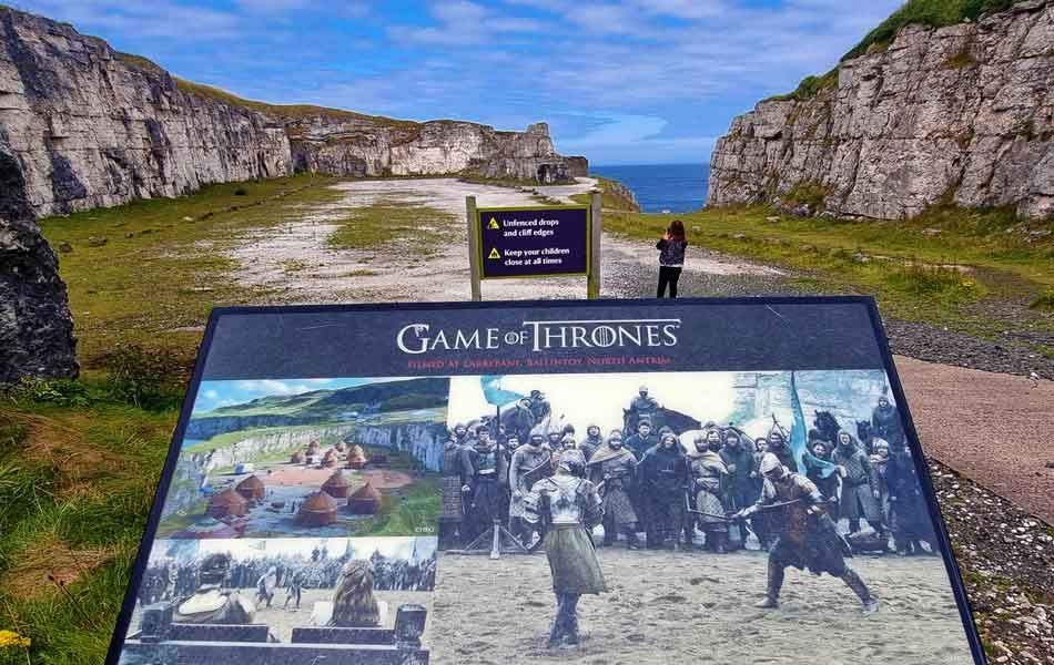 Sign at a Game of Thrones filming location: a landscape with a sign featuring photos from the show