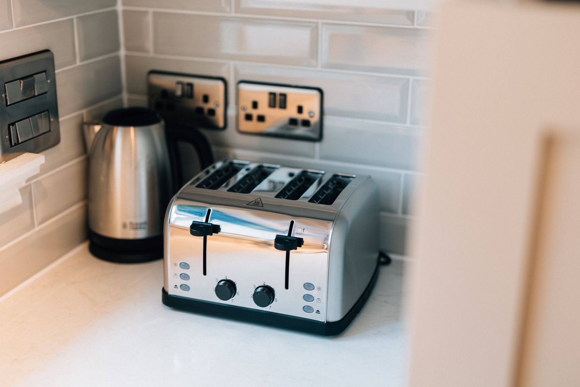 A stainless steel toaster and kettle on a countertop in a kitchen