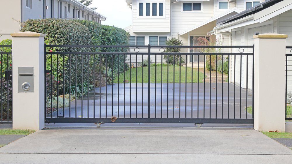 A Sliding Gate Is Open To A Driveway In Front Of A House — NFL Electrical In Mount Archer, QLD