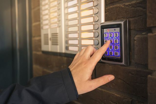 A Person Is Pressing A Button On A Keypad — NFL Electrical In Wamuran, QLD