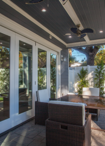 Patio with wicker furniture, glass doors, and a dark ceiling.