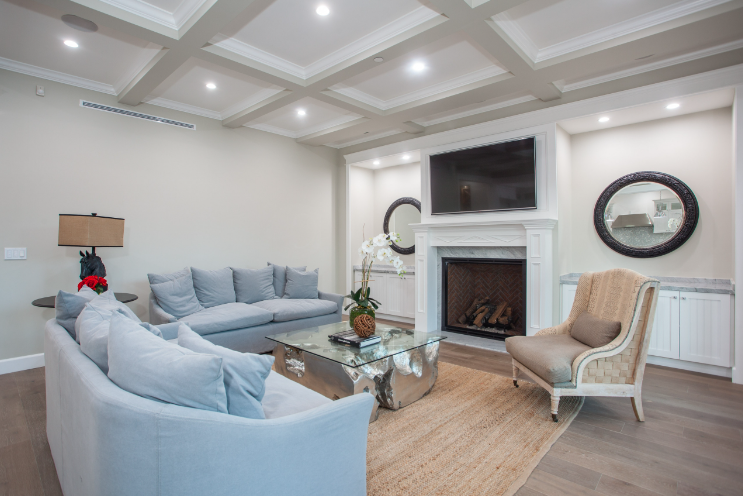 Living room with light blue sofas, a fireplace, and a mirrored coffee table.