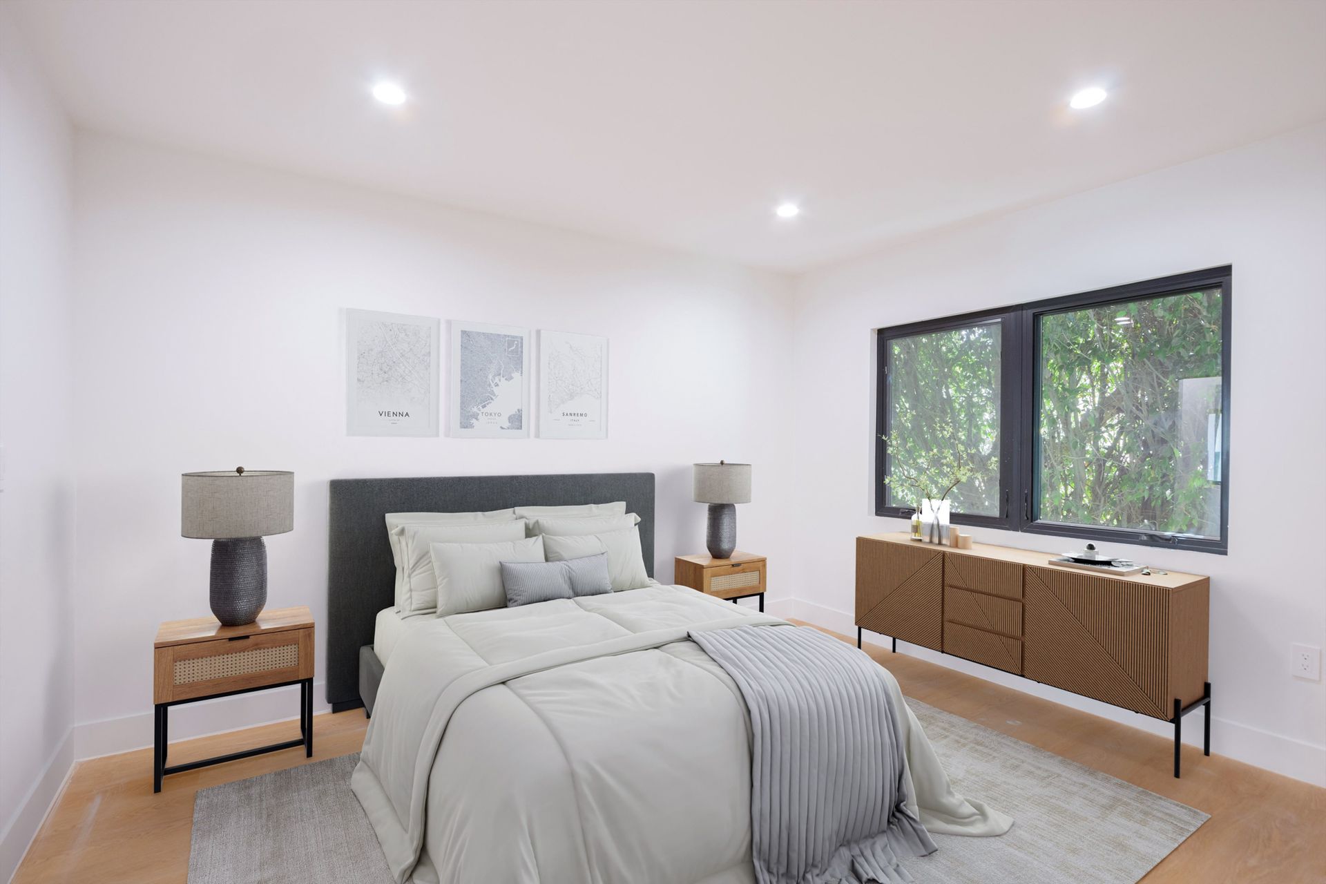 A bedroom with a bed , chair , nightstand , lamp and paintings on the wall.