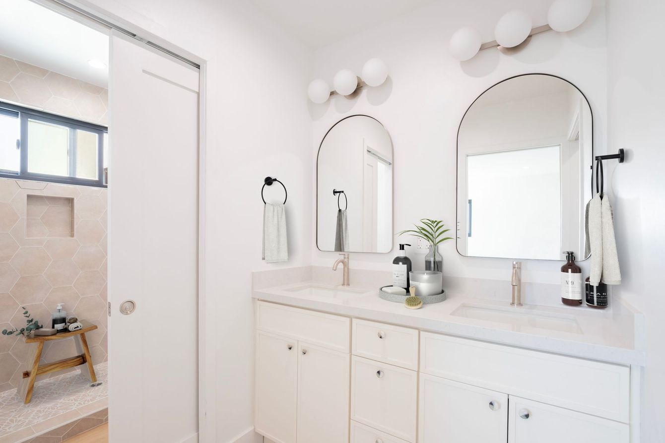 A bathroom with two sinks and two mirrors.