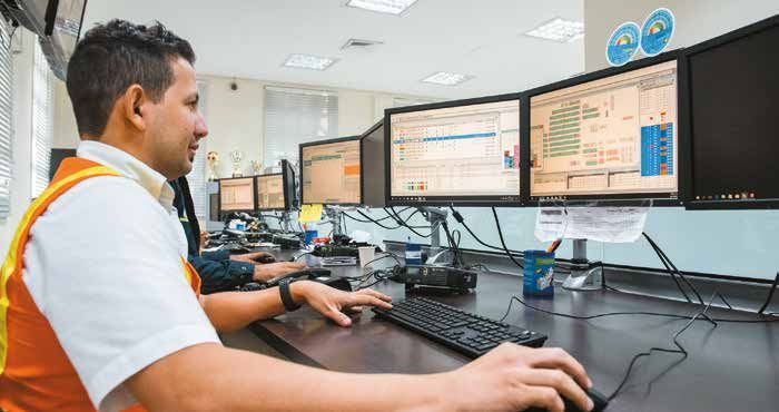 Un hombre está sentado en un escritorio frente a una computadora.