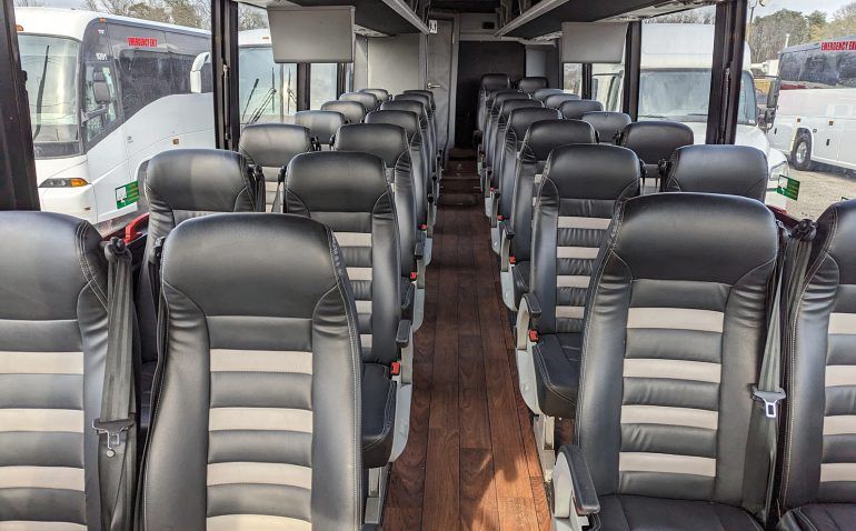 The inside of a bus with a lot of seats and a wooden floor.
