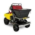 A yellow and black lawn mower with a spreader attached to it.