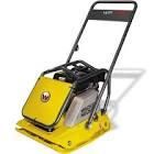 A yellow plate compactor with a handle on a white background.