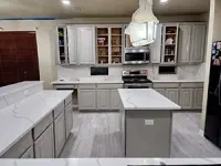 Bright modern kitchen with white cabinets, island, and gray floor tiles