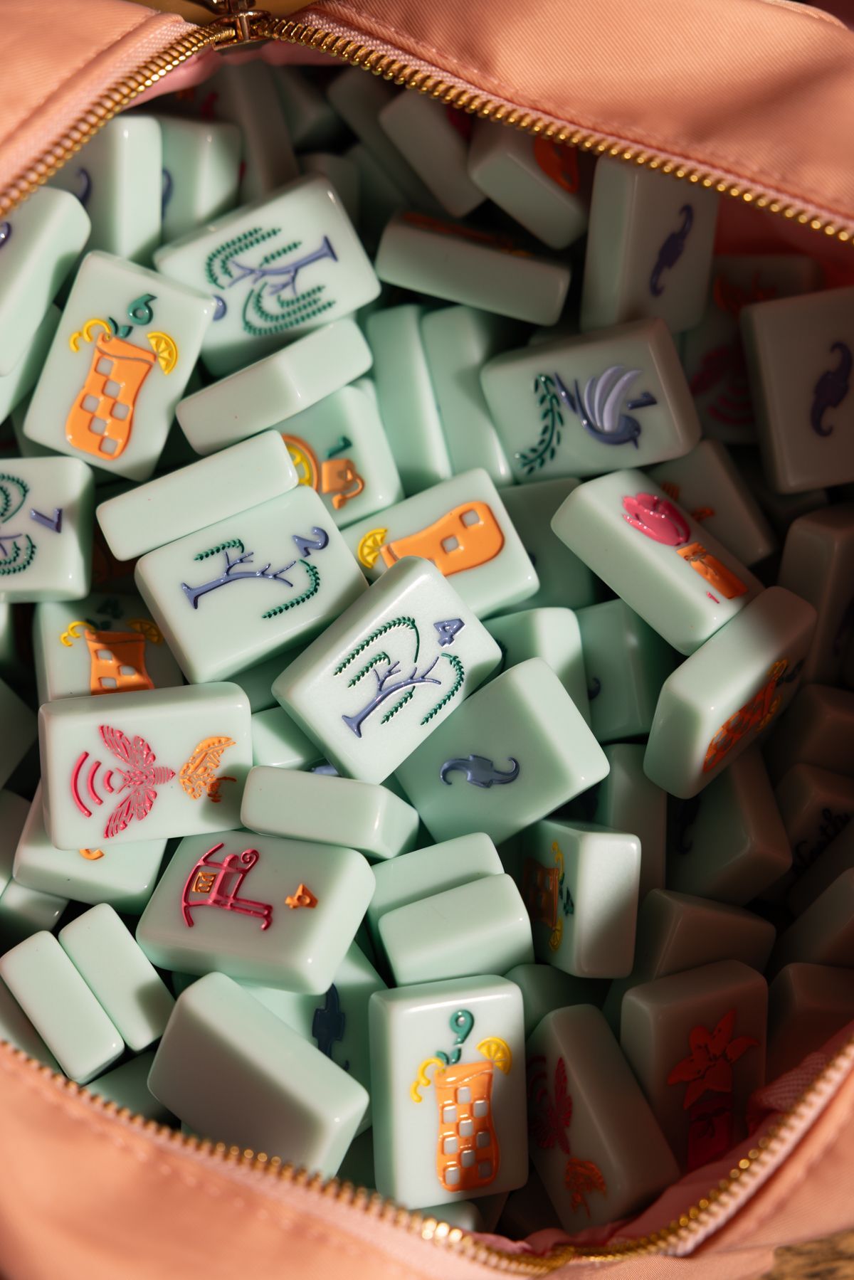 Open bag filled with white domino tiles with colorful markings