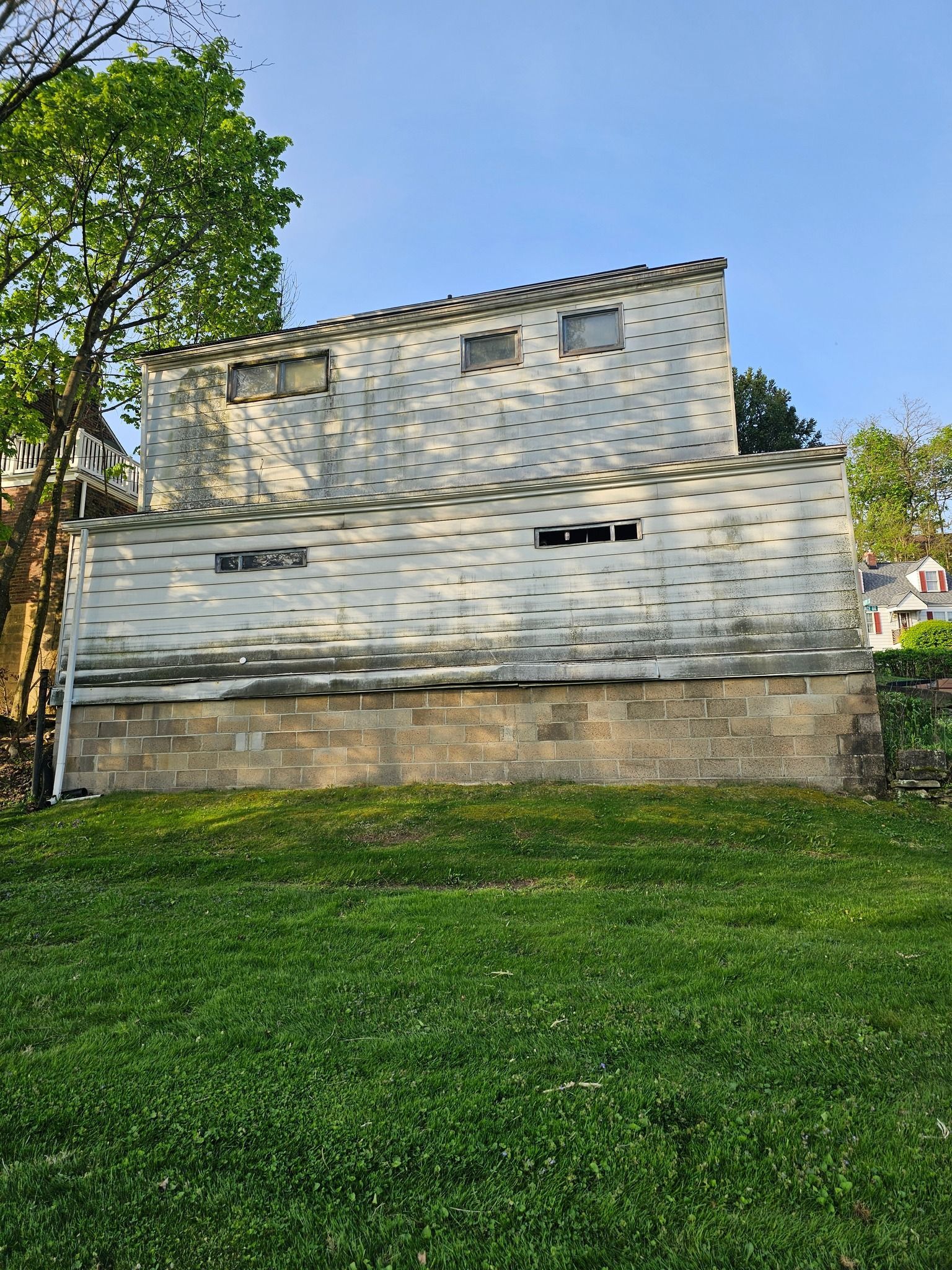 White brick building with dotted pattern on a grassy lawn under a blue sky.