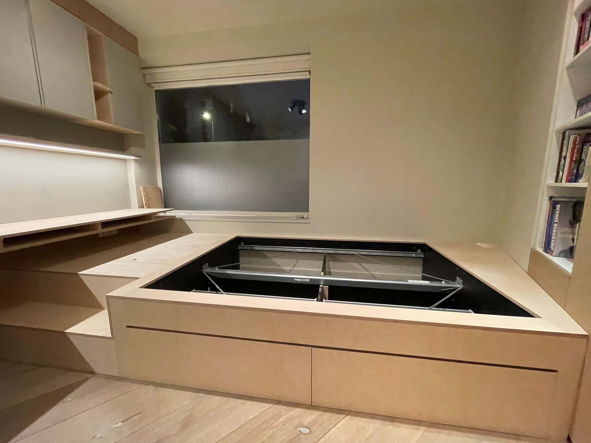Een moderne slaapkamer met een ingebouwd bedframe en bureau. 