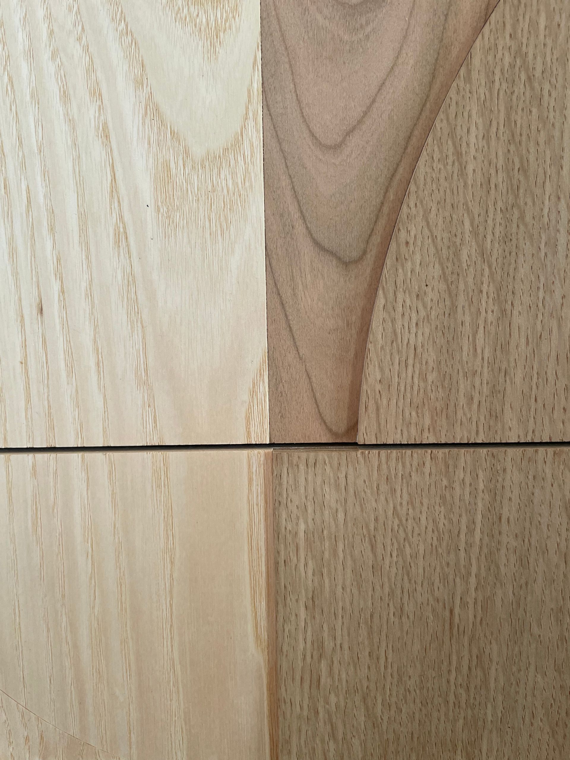Detailopname van een houten vloer. Lichte en donkere houten planken komen samen bij een naad.